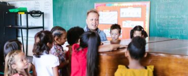 maestro che insegna musica agli alunni vicino a un pianoforte