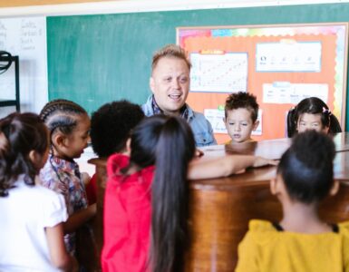 maestro che insegna musica agli alunni vicino a un pianoforte