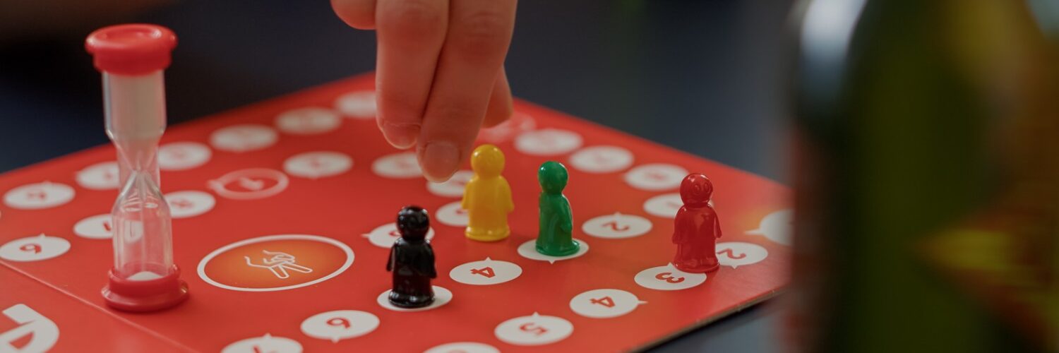 Giovani che giocano al gioco da tavolo sciarade con carte collezionabili