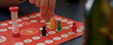 Giovani che giocano al gioco da tavolo sciarade con carte collezionabili