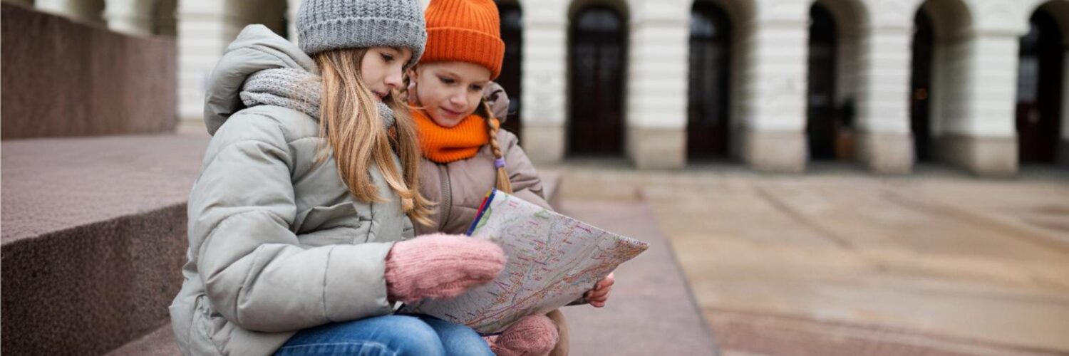 bambine che guardano una mappa durante un gioco di esplorazione in città