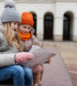 bambine che guardano una mappa durante un gioco di esplorazione in città
